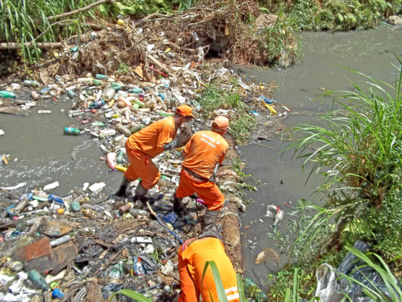 Agentes da Prefeitura retirando lixo de córrego poluído