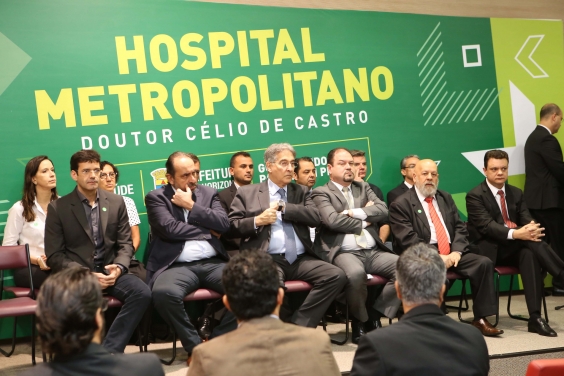 Autoridades compõem mesa de solenidade com painel do hospital metropolitano ao fundo