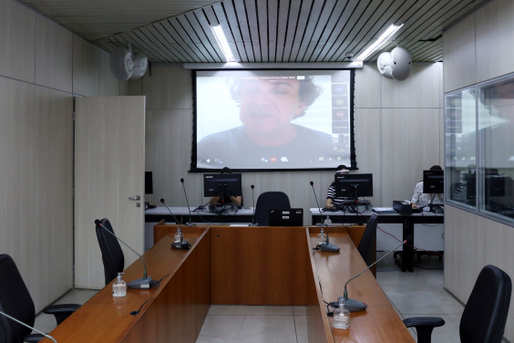 Telão no plenário Camil Caram exibe imagem de Gilson Reis em reunião remota