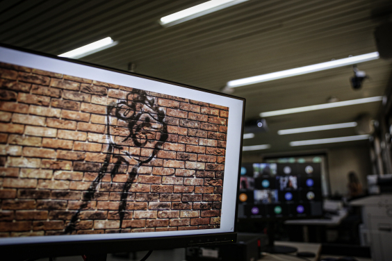 Fundo da tela do computador com textura de parede de tijolos aparentes evidenciando uma mão com punhos fechados - fazendo alusão ao movimento negro