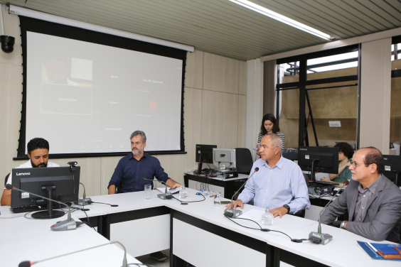 Imagem de quatro vereadores sentados em uma mesa em formato de U