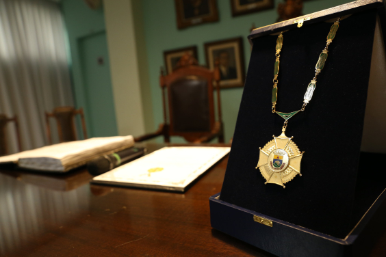Medalha do GRande Colar do Mérito Legislativo em estojo, sob uma mesa