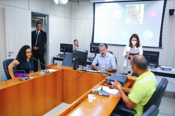 Imagem dos vereadores em reunião, sentados em torno de uma mesa em U