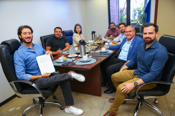 O presidente da Câmara, Gabriel, e o vereador Jorge Santos em reunião com secretários e assessores do Executivo, todos sentados à mesa.