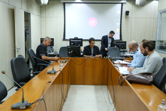Quatro parlamentares sentados à mesa, em reunião. 