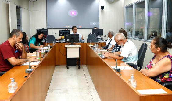 Um parlamentar e sete cidadãos reunidos, sentados à mesa.
