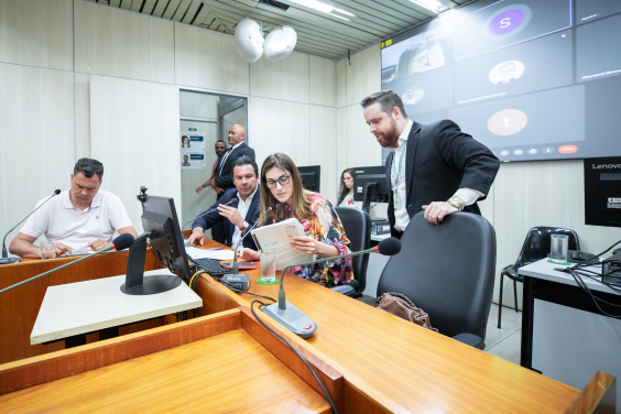 Três parlamentares reunidos, sentados à mesa.
