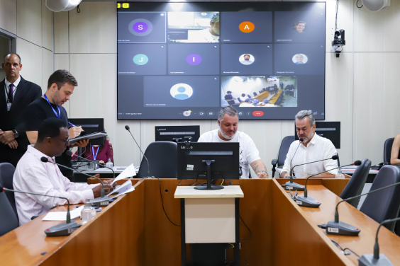 Imagem dos parlamentares Pedro Patrus, Wilsinho da Tabu e Gilson Reis  em torno da mesa em formato de U, durante a reunião. 
