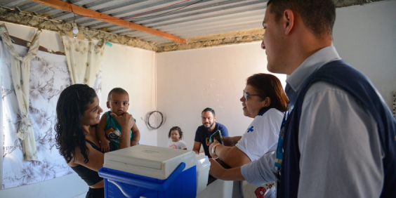 Equipe de saúde em atendimento a mulher com bebê