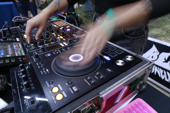 Mãos de um DJ operam equipamento de som durante apresentação em reunião na CMBH