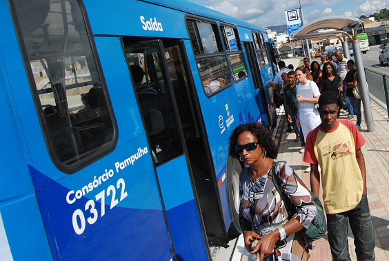 Pessoas aguardam abertura de portas de ônibus azul