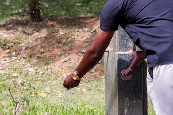 homem retira água de bebedouro público