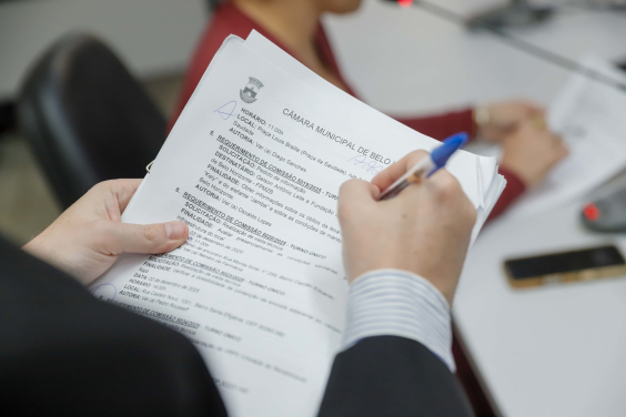 mãos de parlamentar segurando documentos