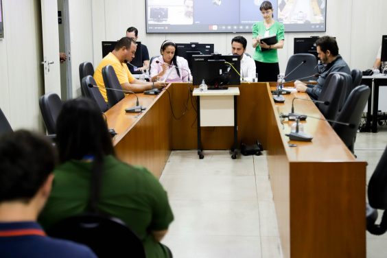 Parlamentares reunidos em volta de mesa durante reunião da Comissão que aprovou parecer favorável ao projeto