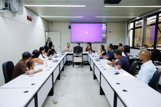 Vereadores, moradores do bairro Montes Claros e representantes da Urbel e Copasa reunidos em mesa durante reunião