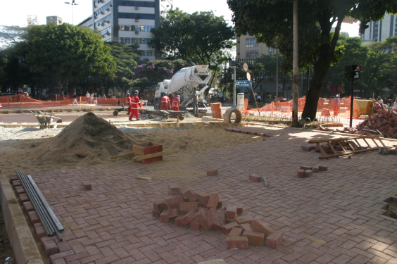 Homens trabalham em reforma de praça