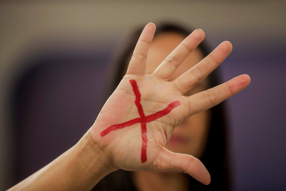 Mão de mulher com um X em vermelho