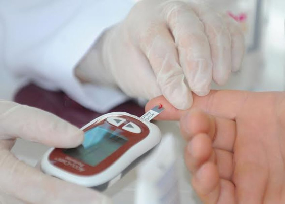 pessoa realiza aferição de glicose em equipamento portátil