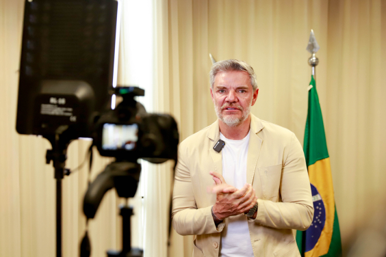 Juliano Lopes fala em frente à câmera em sua sala na CMBH