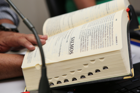 Homem segura Bíblia aberta no início do livro de Salmos