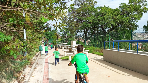 Crianças andam de bicicleta em área verde
