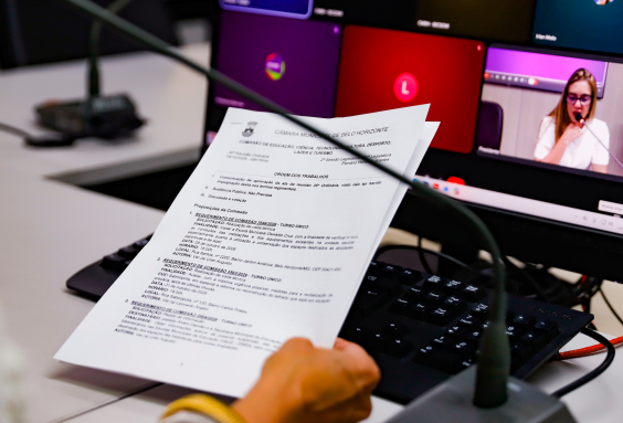 mãos de parlamentar seguram documento de comissão