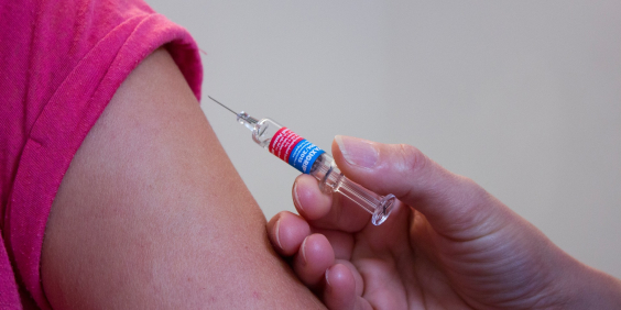 Foto mostra pessoa sendo vacinada 