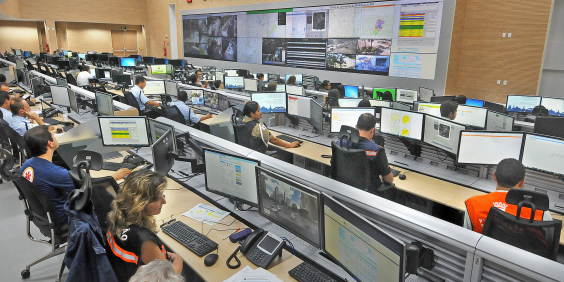 imagem em plano aberto do centro de monitoramento da prefeitura de bh com seus funcionários em atividade