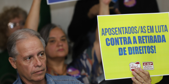 aposentados e pensionistas levantam cartazes e realizam manifestação