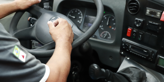 close nas mãos de motorista segurando voltante de automóvel