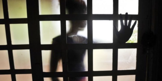 criança atrás de uma janela, em negativo