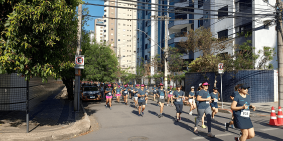 pessoas participam de corrida de rua em via pública