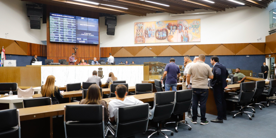 Vereadores sentados e em pé durante reunião do Plenário