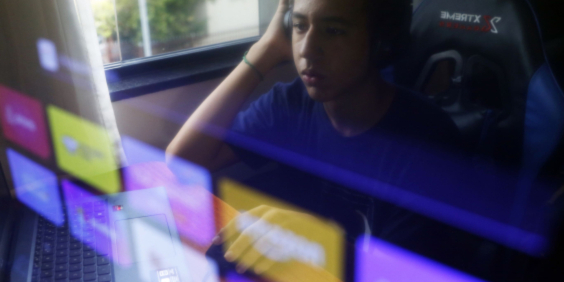 reflexo de um adolescente na tela de um computador