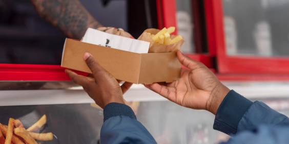close nas mãos de vendedor de alimentos entregando caixa para cliente