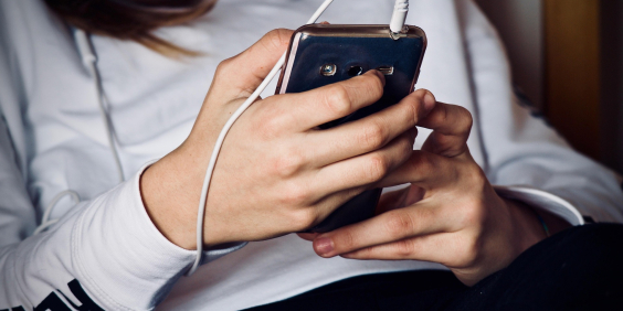 Jovem mexe em celular
