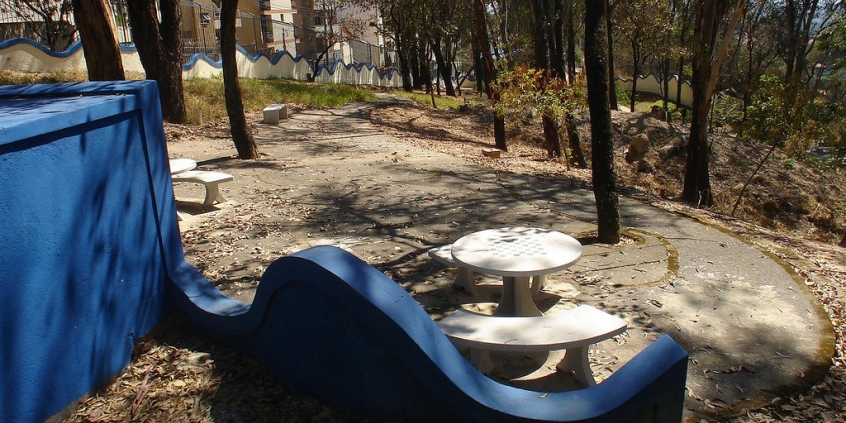 Mesas, bancos e cadeira em praça de Parque Público