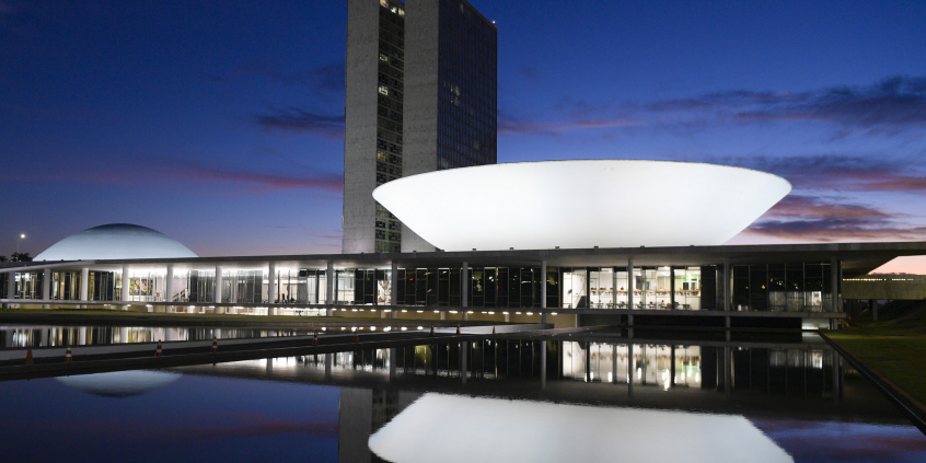 Imagem noturna da fachada do Congresso Nacional em Brasília; em destaque, a Câmara dos Deputados