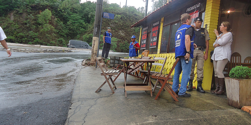 foto mostra fiscais da Prefeitura durante abordagem a bar com mesas na calçada
