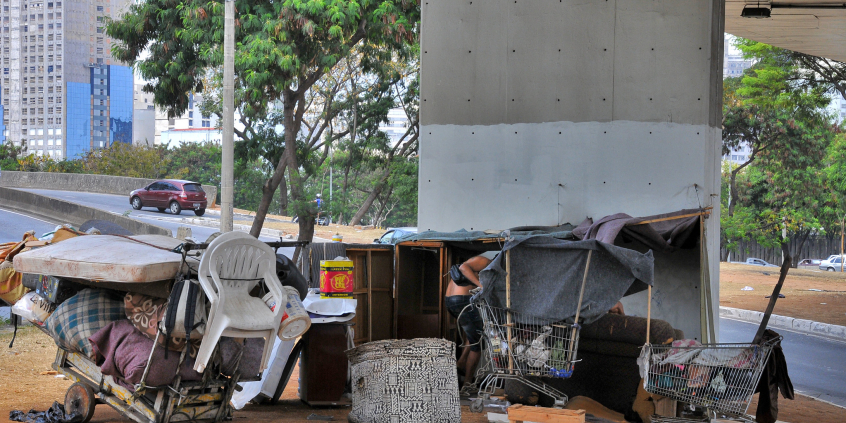 Barraca de lona improvisada, carrinho de supermercado, colchão e caixotes de madeira servem como abrigo para morador de rua