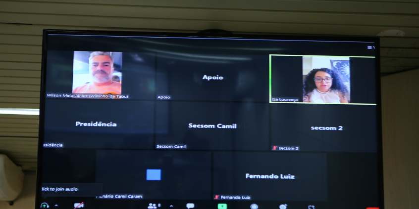 Homem e mulher em tela de computador, participando de reunião remota.