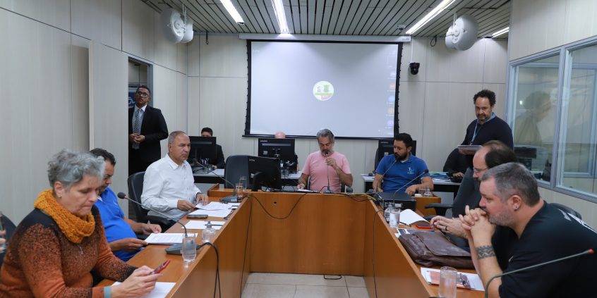 Seis vereadores e uma vereadora em reunião, sentados à mesa.