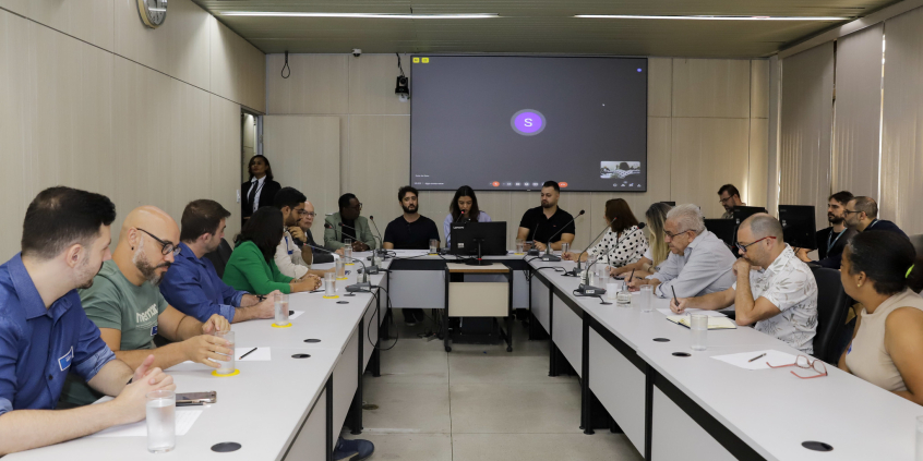 Quinze pessoas reunidas, sentadas à mesa.