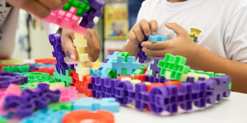 Criança mexe com brinquedo de montar em sala de aula