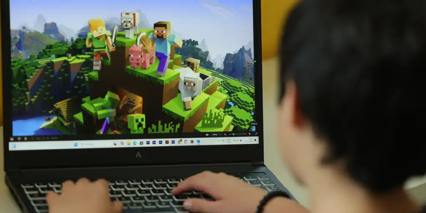 Criança joga em laptop