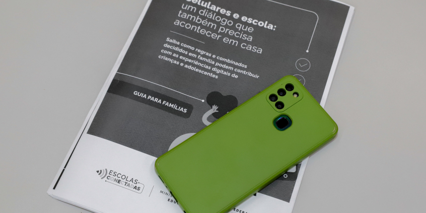 Celular em cima de livreto