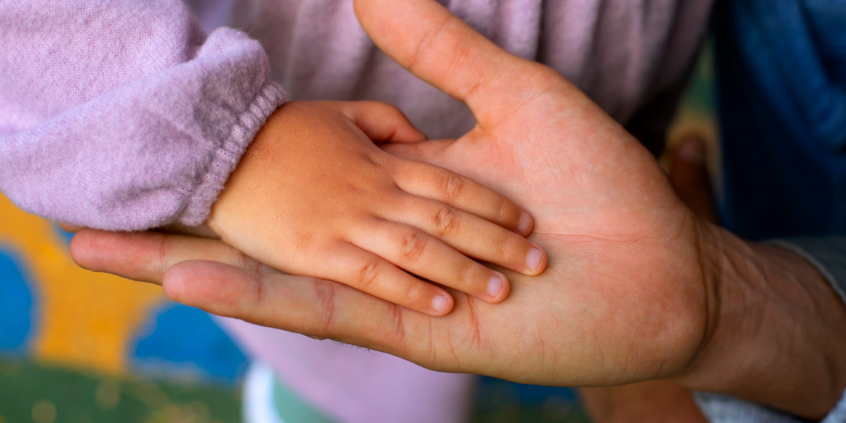 duas mão, uma de adulto e outra de criança