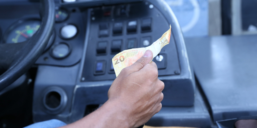 close nas mãos de motorista de ônibus recebendo dinheiro de passageiro do transporte público