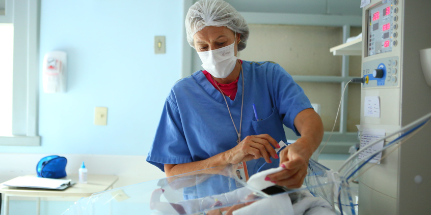 Enfermeira atendendo bebê em uti neonatal