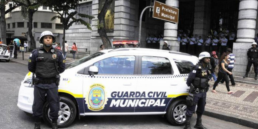 agentes da guarda municipal ao lado de veículo da corporação